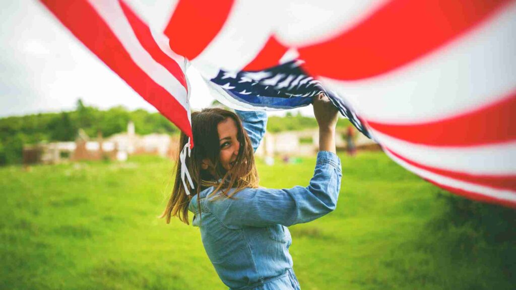 A girl running and holding US flag