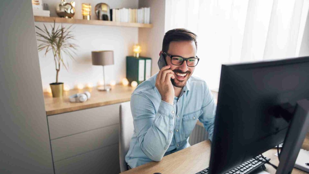 A man on the phone while looking at the monitor