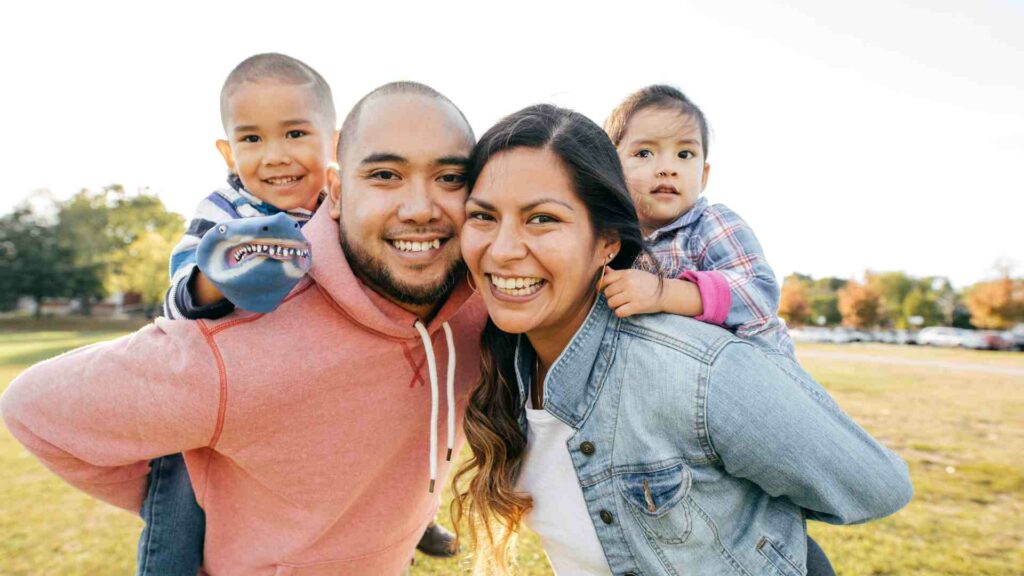 Happy parents with two children smiling under E2 Visa