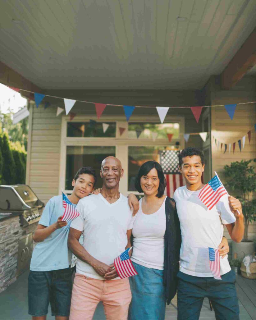 A mixed race family holding US flags