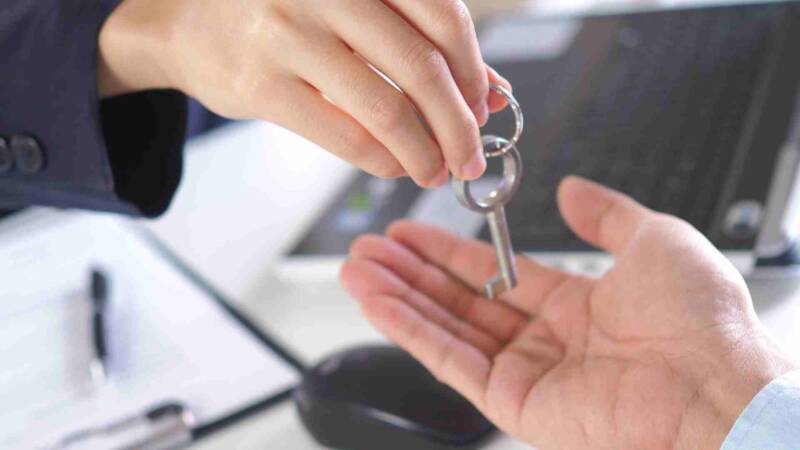 A woman giving a key to the new property owner
