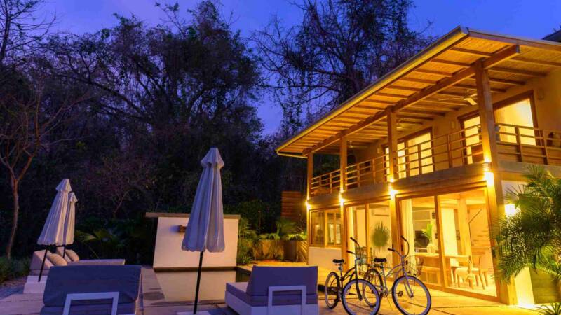 A luxury short term rental at night with pool and bikes