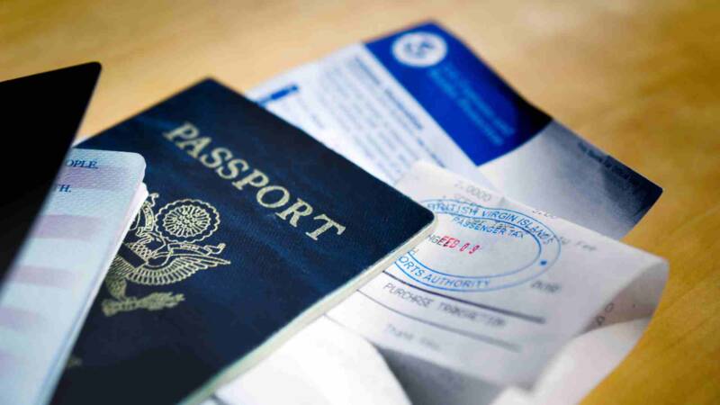 The E-2 visa requirements paper inside a passport with other document.