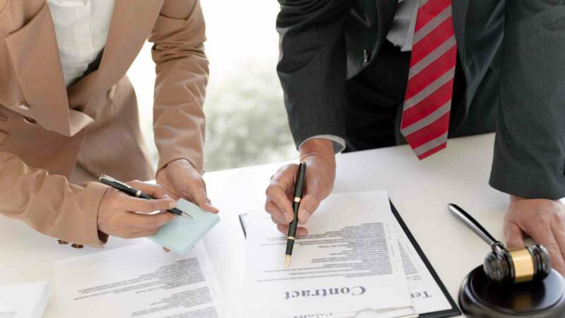 A contract being reviewed with a lawyer and a client