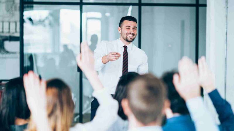 A franchise training with a lot of audience raising hands