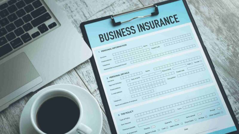 Business insurance form with a laptop and a cup of coffee