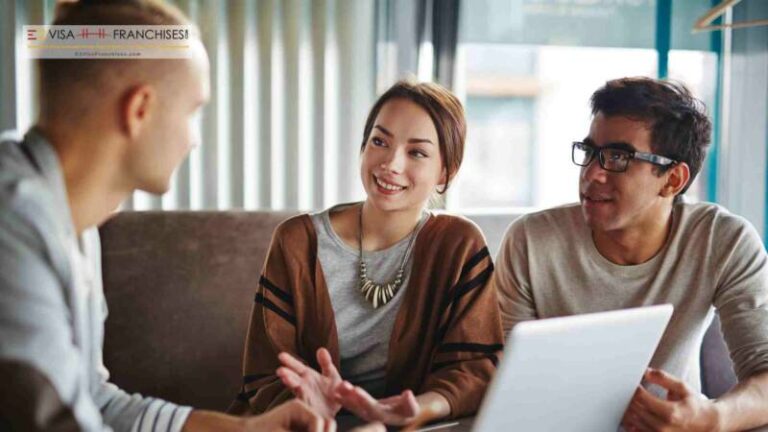 An e2 visa franchise consultant discussing potential franchise with a couple