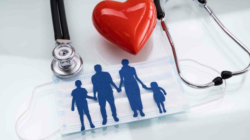 A miniature of a family holding hand with a mask behind it