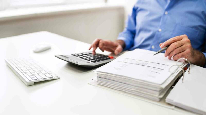 Calculating tax with a bag pile of documents and calculator