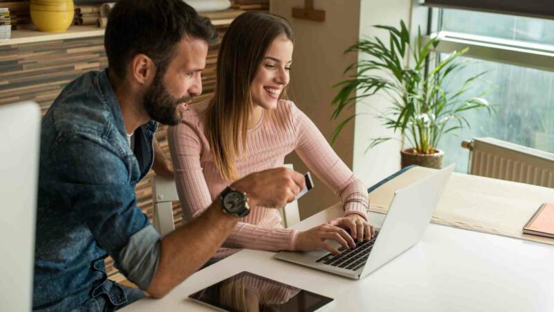 A spouse smiling in front of laptop