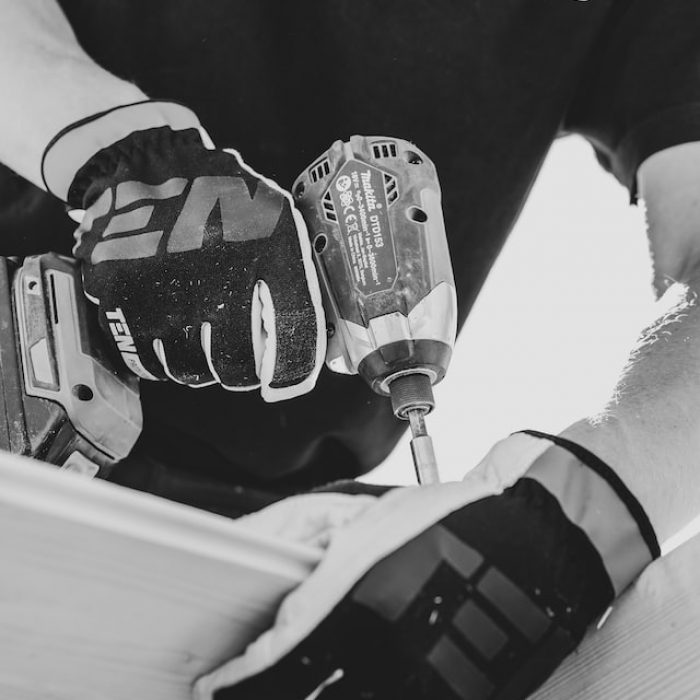 A man drilling a wood in black and white